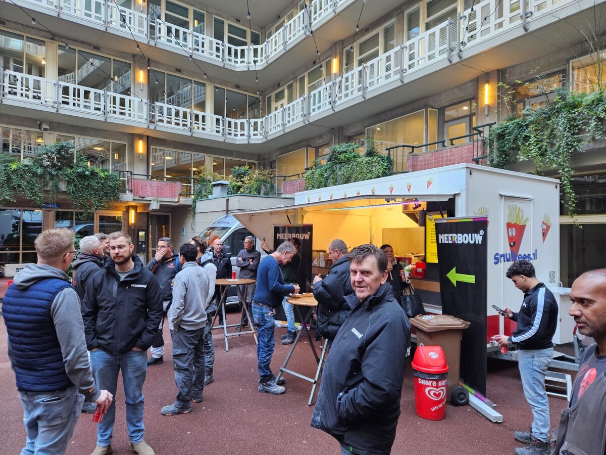 Druk bedrijfsevent in een binnenplaats met Smulkees catering