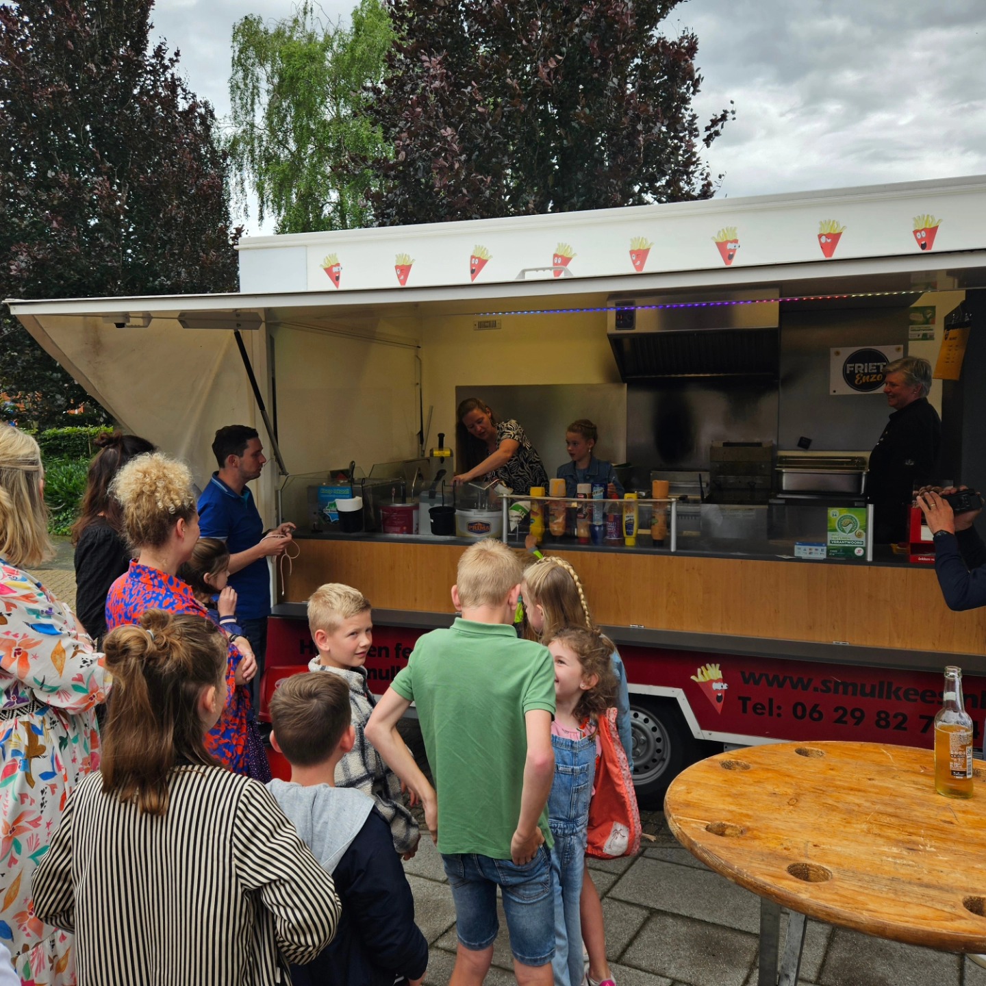 Kinderen wachten op friet bij de Smulkees wagen